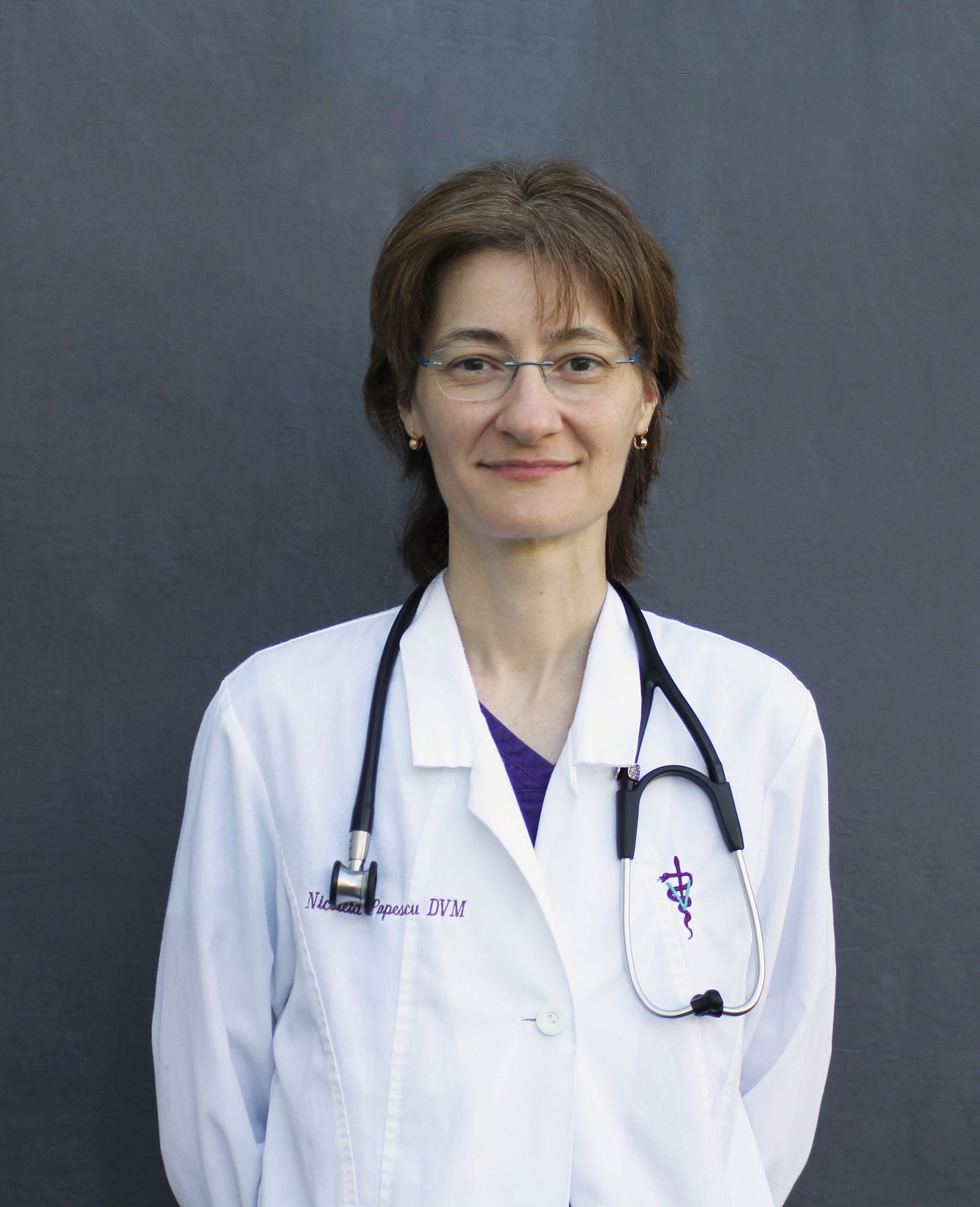 Dr. Nicoleta Popescu, a tall, slim female veterinarian in a white lab coat.